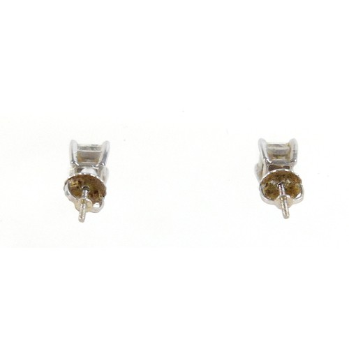 180 - A pair of 14ct white gold  diamond solitaire stud earrings, the princess cut stones each approximate... 