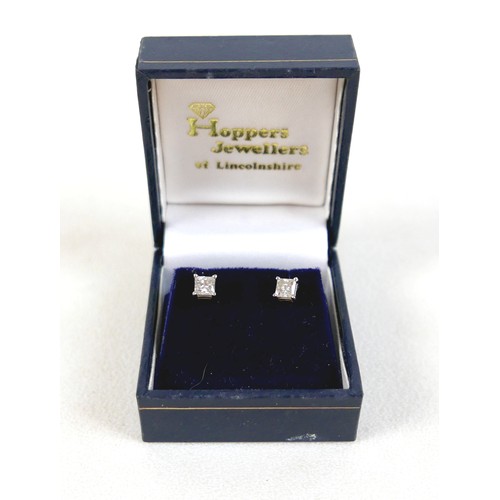 180 - A pair of 14ct white gold  diamond solitaire stud earrings, the princess cut stones each approximate... 