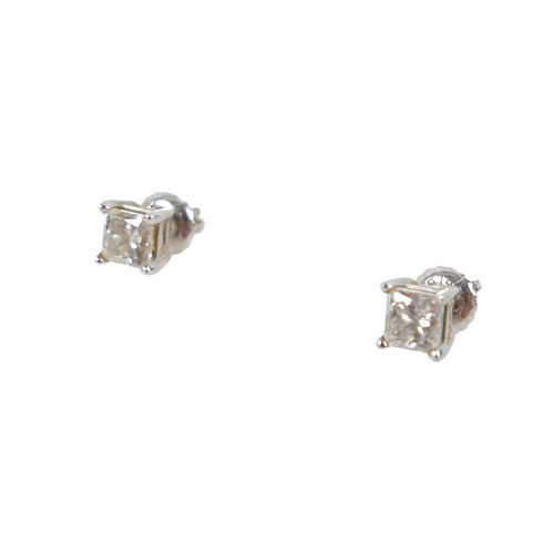 180 - A pair of 14ct white gold  diamond solitaire stud earrings, the princess cut stones each approximate... 