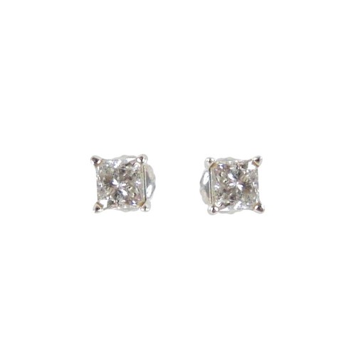 180 - A pair of 14ct white gold  diamond solitaire stud earrings, the princess cut stones each approximate... 