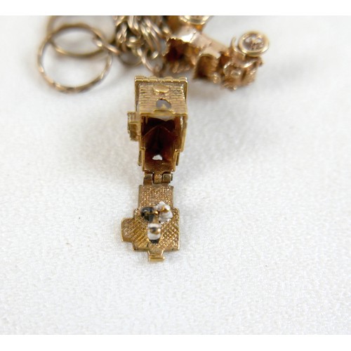 174 - A 9ct yellow gold charm bracelet with eight charms, 25.7g.