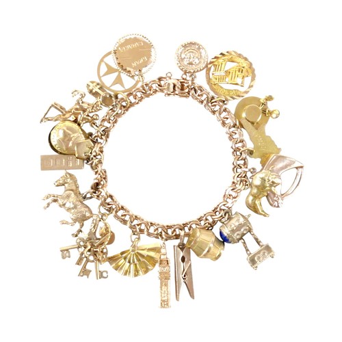 176 - A 9ct gold charm bracelet with assorted 9ct gold, 18ct and gilt metal charms, including 9ct Melton M...