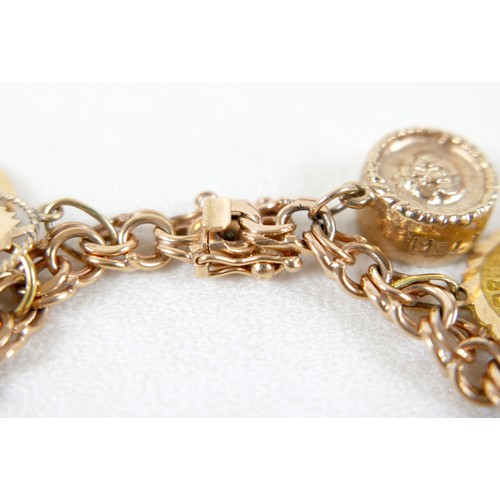 176 - A 9ct gold charm bracelet with assorted 9ct gold, 18ct and gilt metal charms, including 9ct Melton M... 