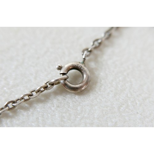 87 - A small group of silver and white metal jewellery, including a charm bracelet, two rings, sports med... 