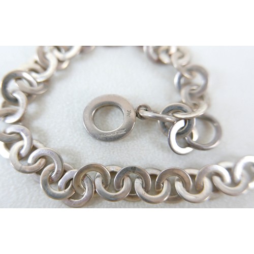87 - A small group of silver and white metal jewellery, including a charm bracelet, two rings, sports med... 