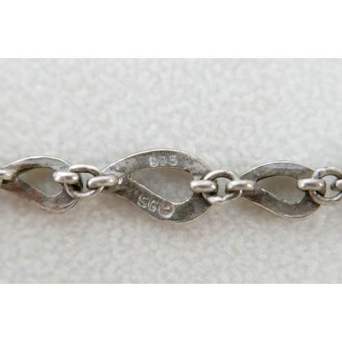 87 - A small group of silver and white metal jewellery, including a charm bracelet, two rings, sports med... 