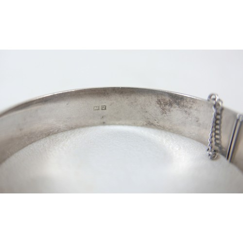 87 - A small group of silver and white metal jewellery, including a charm bracelet, two rings, sports med... 