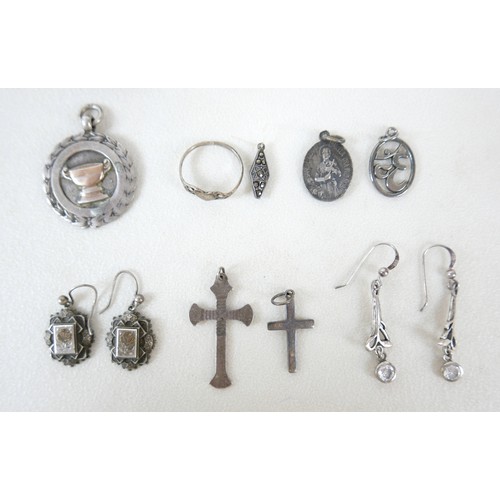 87 - A small group of silver and white metal jewellery, including a charm bracelet, two rings, sports med... 