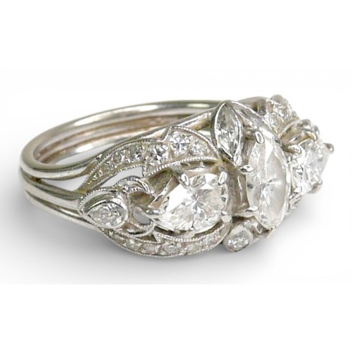 174 - A diamond set fancy cluster ring, centering on a marquise cut diamond, measuring 7.1mm by 4.2mm, dep... 