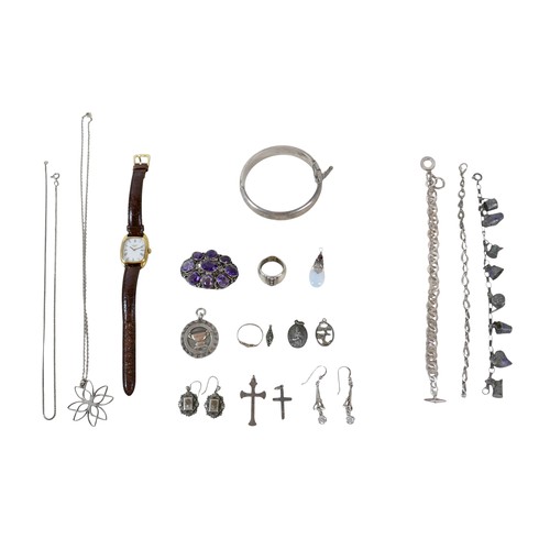 87 - A small group of silver and white metal jewellery, including a charm bracelet, two rings, sports med... 
