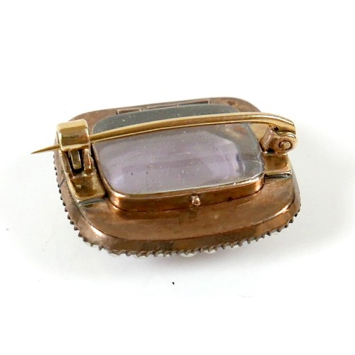 44 - A yellow metal mourning brooch with a central amethyst surrounded by seed pearls, 23 by 20 by 12mm, ... 