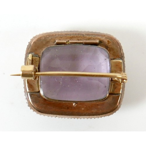 44 - A yellow metal mourning brooch with a central amethyst surrounded by seed pearls, 23 by 20 by 12mm, ... 
