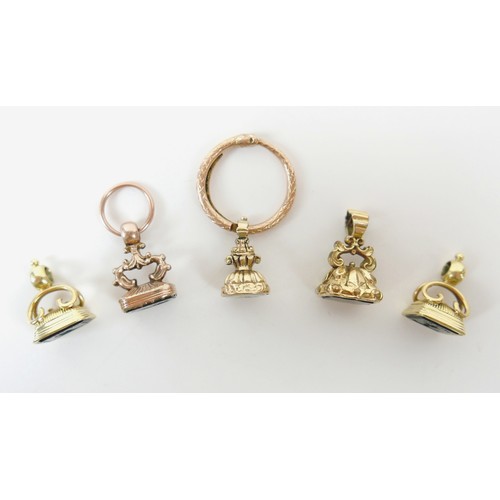 15 - A collection of five yellow metal fobs a serpent ring, four are intaglio, largest fob 16 by 14 by 24... 