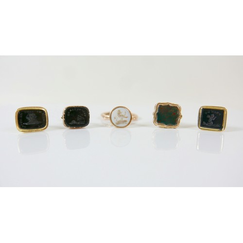 15 - A collection of five yellow metal fobs a serpent ring, four are intaglio, largest fob 16 by 14 by 24... 