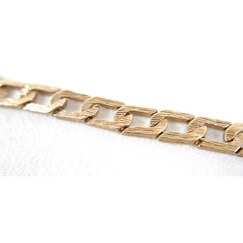 13 - A 9ct gold identity bracelet, with flat curb link, bark effect chain, blank identity tag, 20.5cm lon... 