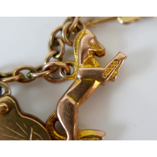 11 - A 9ct yellow gold charm bracelet with twenty charms, 35.3g.