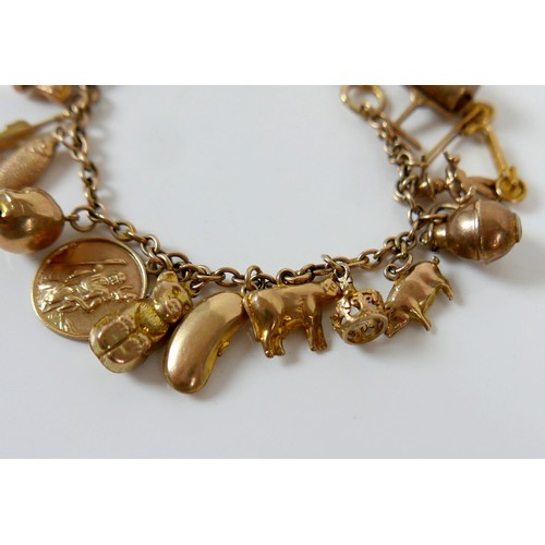 11 - A 9ct yellow gold charm bracelet with twenty charms, 35.3g.