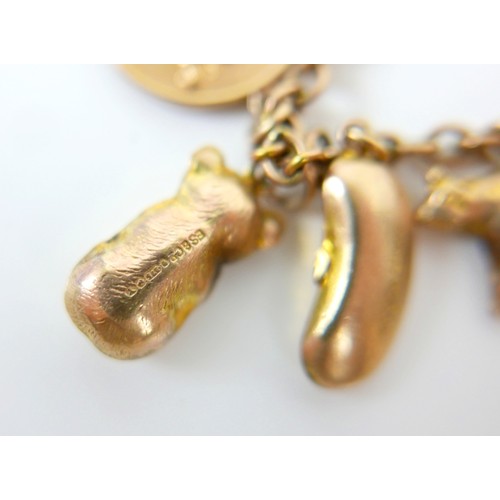 11 - A 9ct yellow gold charm bracelet with twenty charms, 35.3g.