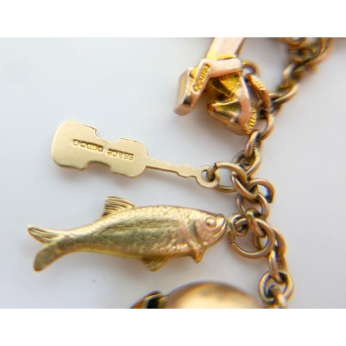11 - A 9ct yellow gold charm bracelet with twenty charms, 35.3g.