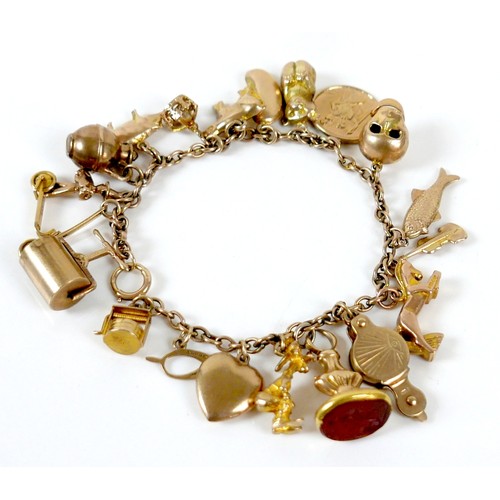 11 - A 9ct yellow gold charm bracelet with twenty charms, 35.3g.