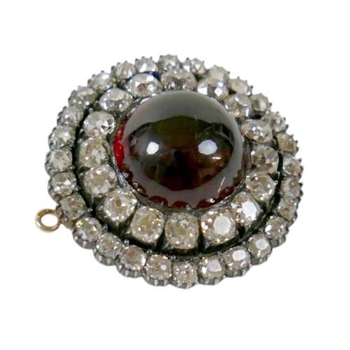 9 - A 19th century yellow metal diamond brooch with a central red paste cabochon 13mm diameter surrounde... 