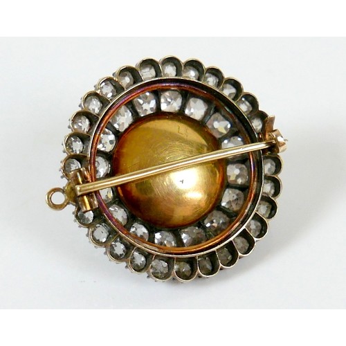 9 - A 19th century yellow metal diamond brooch with a central red paste cabochon 13mm diameter surrounde... 