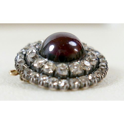 9 - A 19th century yellow metal diamond brooch with a central red paste cabochon 13mm diameter surrounde... 
