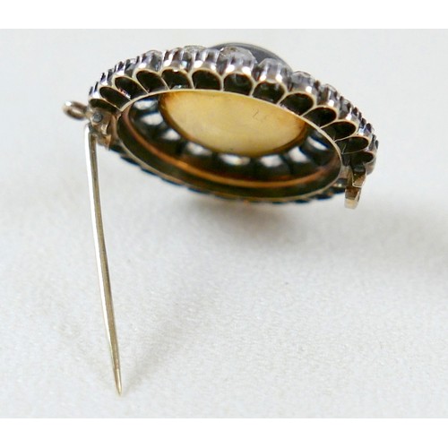 9 - A 19th century yellow metal diamond brooch with a central red paste cabochon 13mm diameter surrounde... 