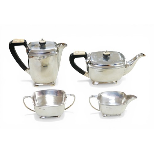 220 - A George VI Art Deco style silver four piece tea set, with two tone mounts to handles and finials of... 