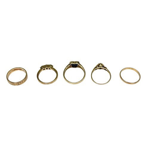 23 - A group of five 9ct gold rings, comprising a three stone peridot ring, each stone 3.5mm, size K, a b... 