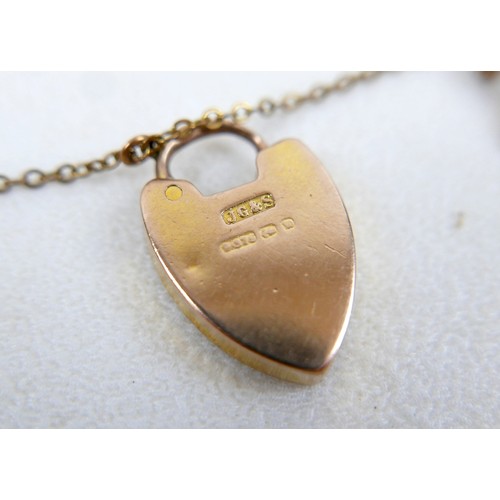 6 - A 9ct gold kerb link charm bracelet, with heart shaped padlock clasp and safety chain, fitted with f... 