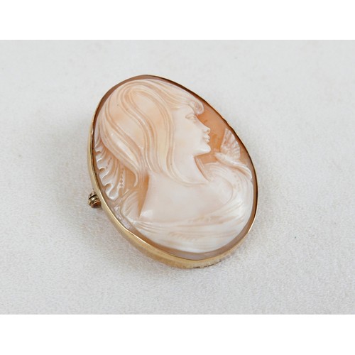 42 - A 9ct gold mounted shell carved shell cameo brooch, carved with a lady's head and bird, 3.5 by 4.5cm... 