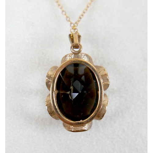 44 - A 9ct gold and smoky quartz pendant on thin gold chain, 48cm long, the central stone a large oval, t... 