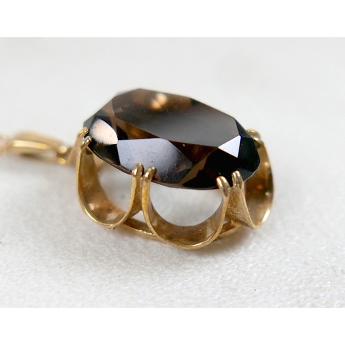 44 - A 9ct gold and smoky quartz pendant on thin gold chain, 48cm long, the central stone a large oval, t... 