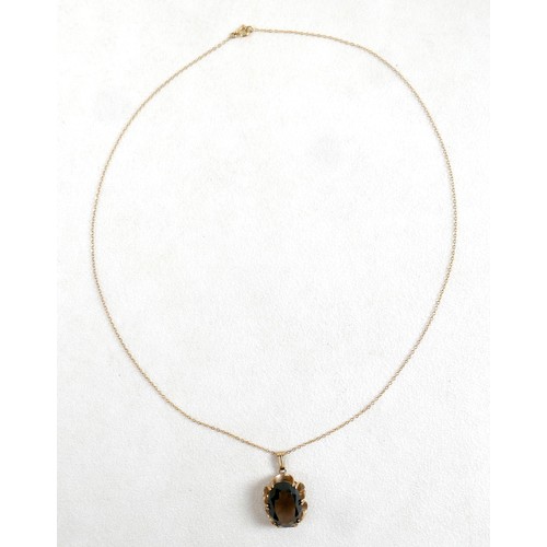 44 - A 9ct gold and smoky quartz pendant on thin gold chain, 48cm long, the central stone a large oval, t... 