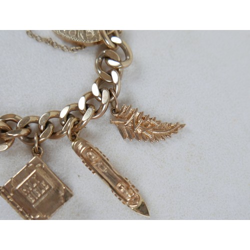 1 - A 9ct gold charm bracelet, flat curb, with assorted 9ct and 14ct gold charms including dolphins, bib... 
