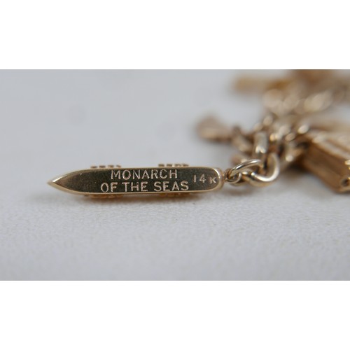 1 - A 9ct gold charm bracelet, flat curb, with assorted 9ct and 14ct gold charms including dolphins, bib... 