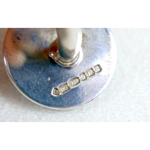 18 - A pair of modern silver cufflinks, ball return style with circular fronts decorated in a swirling de... 