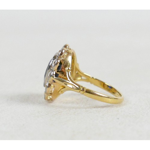 6 - An 18ct gold and platinum set sapphire and diamond flowered ring, size L / M, the oval cushion cut s... 
