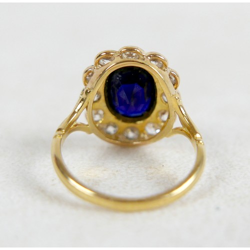6 - An 18ct gold and platinum set sapphire and diamond flowered ring, size L / M, the oval cushion cut s... 