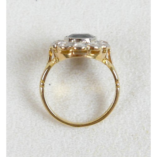 6 - An 18ct gold and platinum set sapphire and diamond flowered ring, size L / M, the oval cushion cut s... 