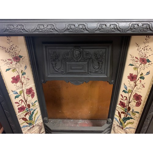 139 - Vintage cast iron fire place decorated with hand painted tiles along with fender.