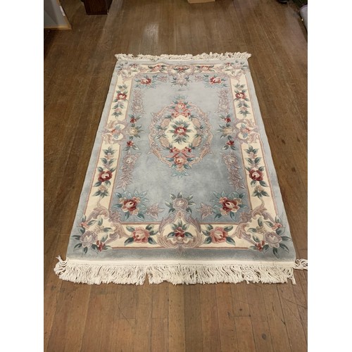 240 - Light blue, floral floor rug.