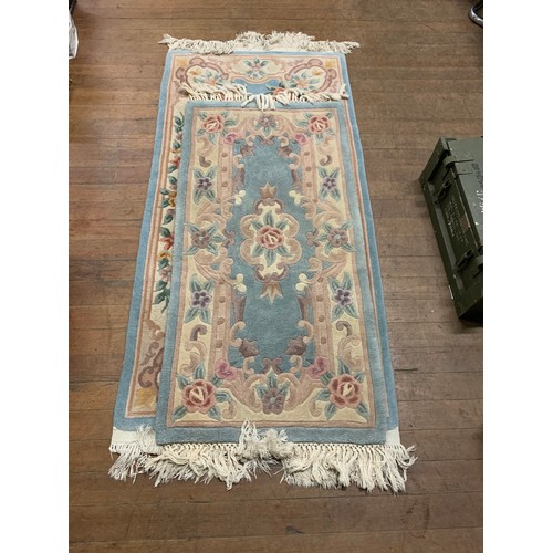 246 - 2 light blue floral rugs.