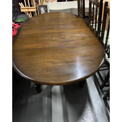 35 - Ercol elm wood dining table with leaf Centre, along with 4 Ercol high back chairs.