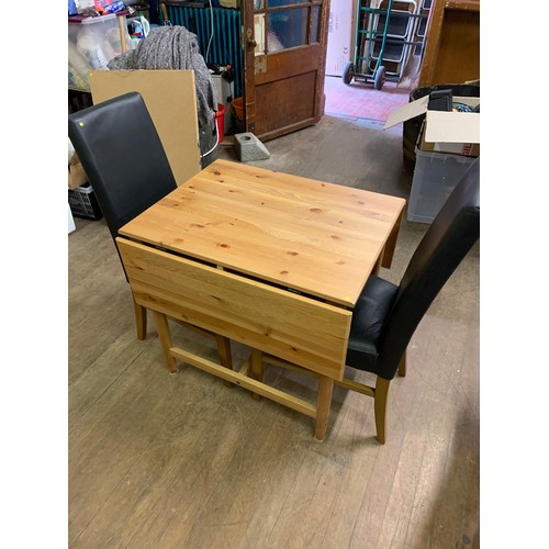 85 - Pine drop-leaf dining table with two matching chairs.
