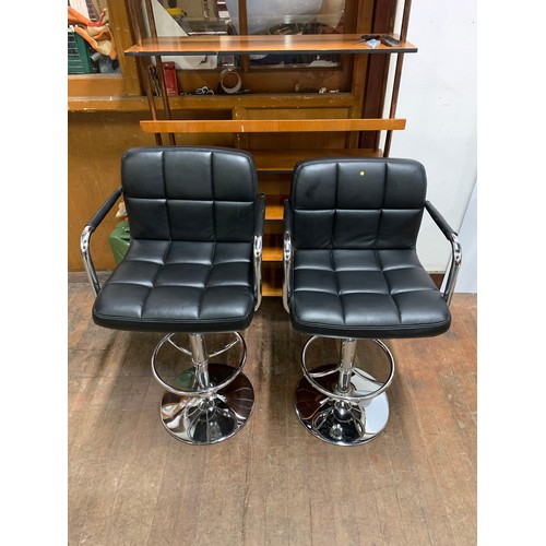 110 - Pair of black leather and chrome stools.
