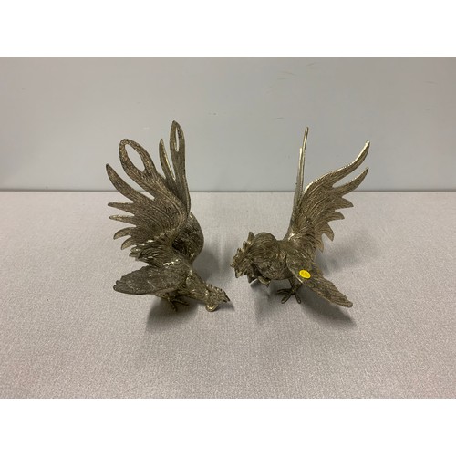 31 - Pair of white metal fighting cockerel figures.