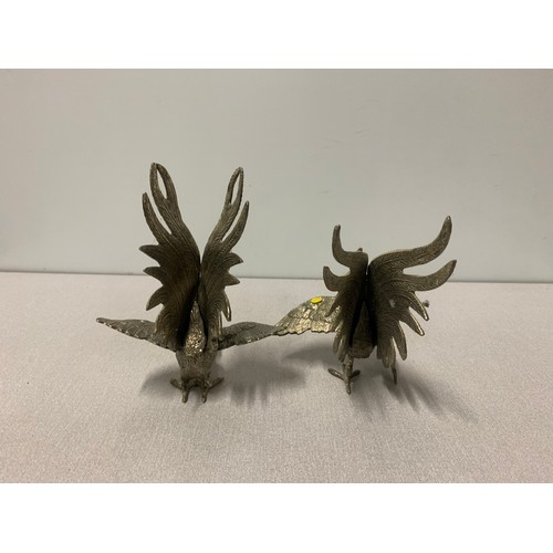 31 - Pair of white metal fighting cockerel figures.