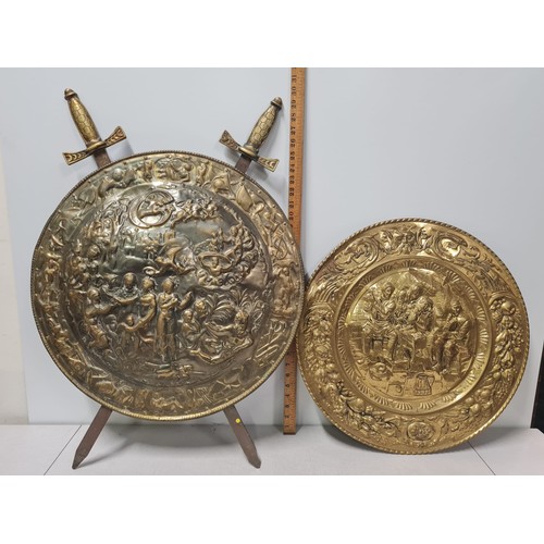 49 - Large brass wall hanging shield with crossed swords depicting mythical scene Circa 1930's along with... 